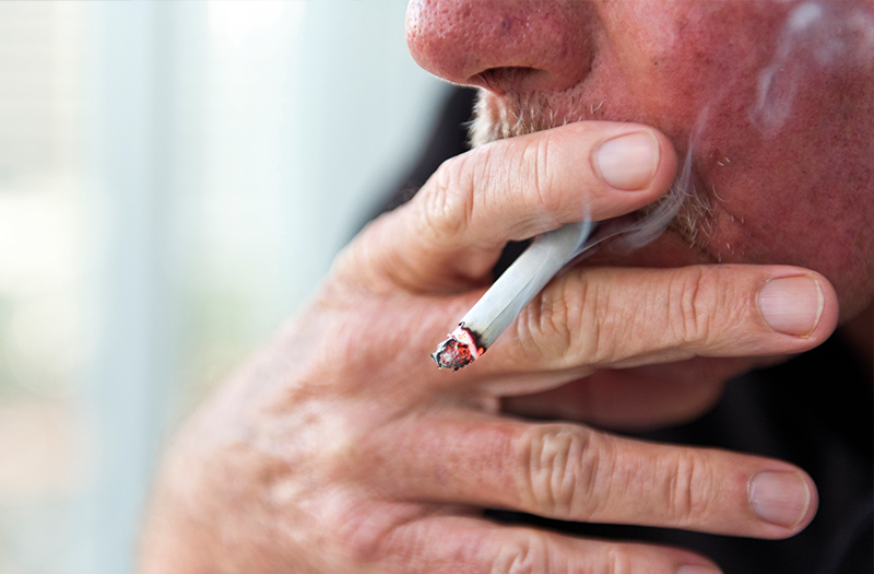 Person holding and smoking a cigarette