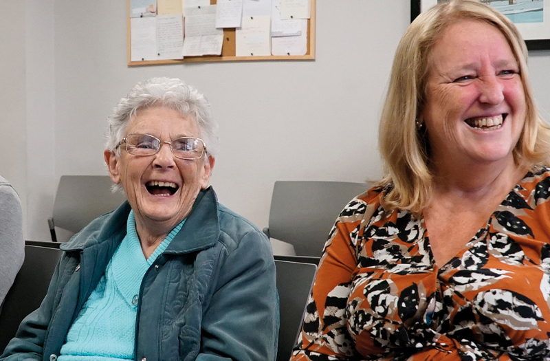 A smiling SpaMedica patient sat between her happy family members in the SpaMedica waiting room