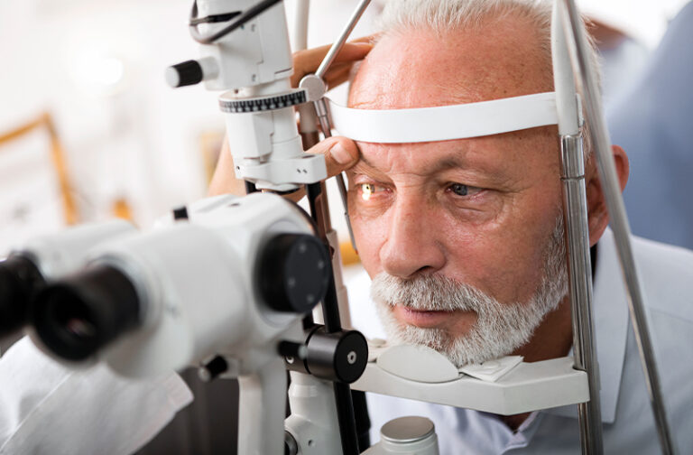 An elderly gentleman having his eye examined with a slit lamp