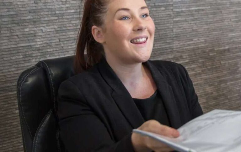 SpaMedica Patient Co-ordinator smiling and handing leaflet to patient