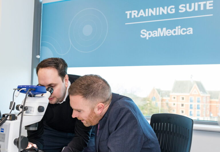 A SpaMedica employee demonstrating to a Local Member of Parliament how to operate a piece of optical examination equipment