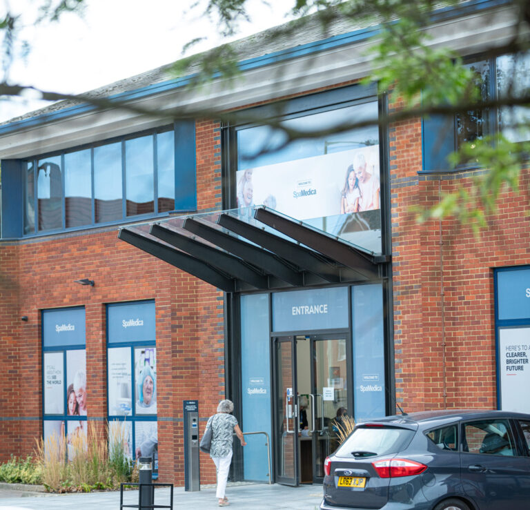 The exterior of the SpaMedica Wokingham hospital building with a SpaMedica patient walking through the front doors