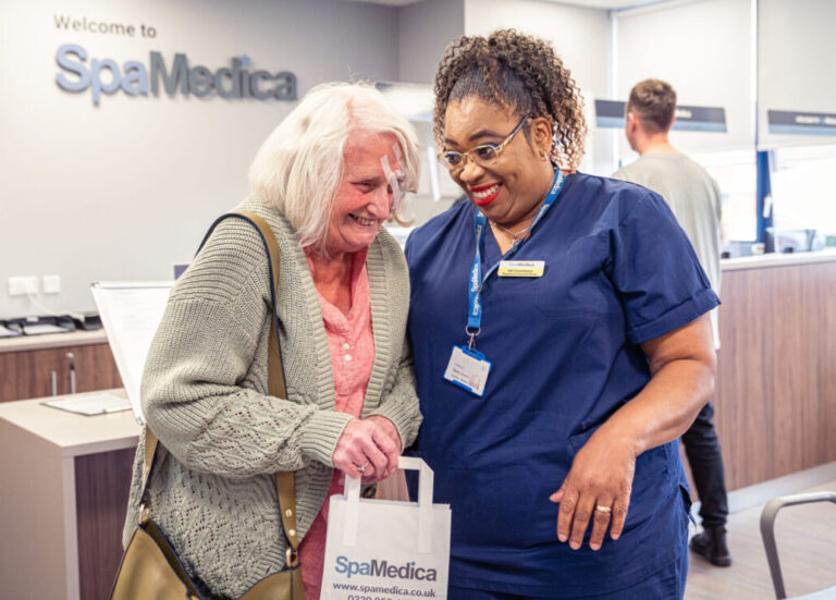 SpaMedica nurse laughing away with patient wearing face mask post surgery