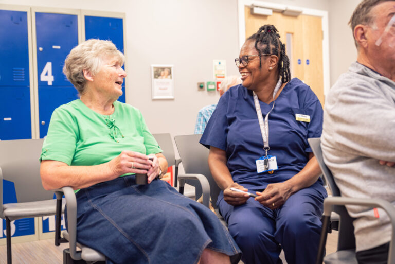 SpaMedica nurse in patient waiting room happily chatting with patient