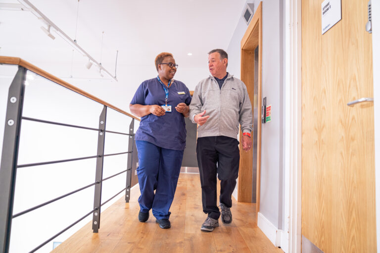 Happy SpaMedica nurse walking and chatting with patient post surgery