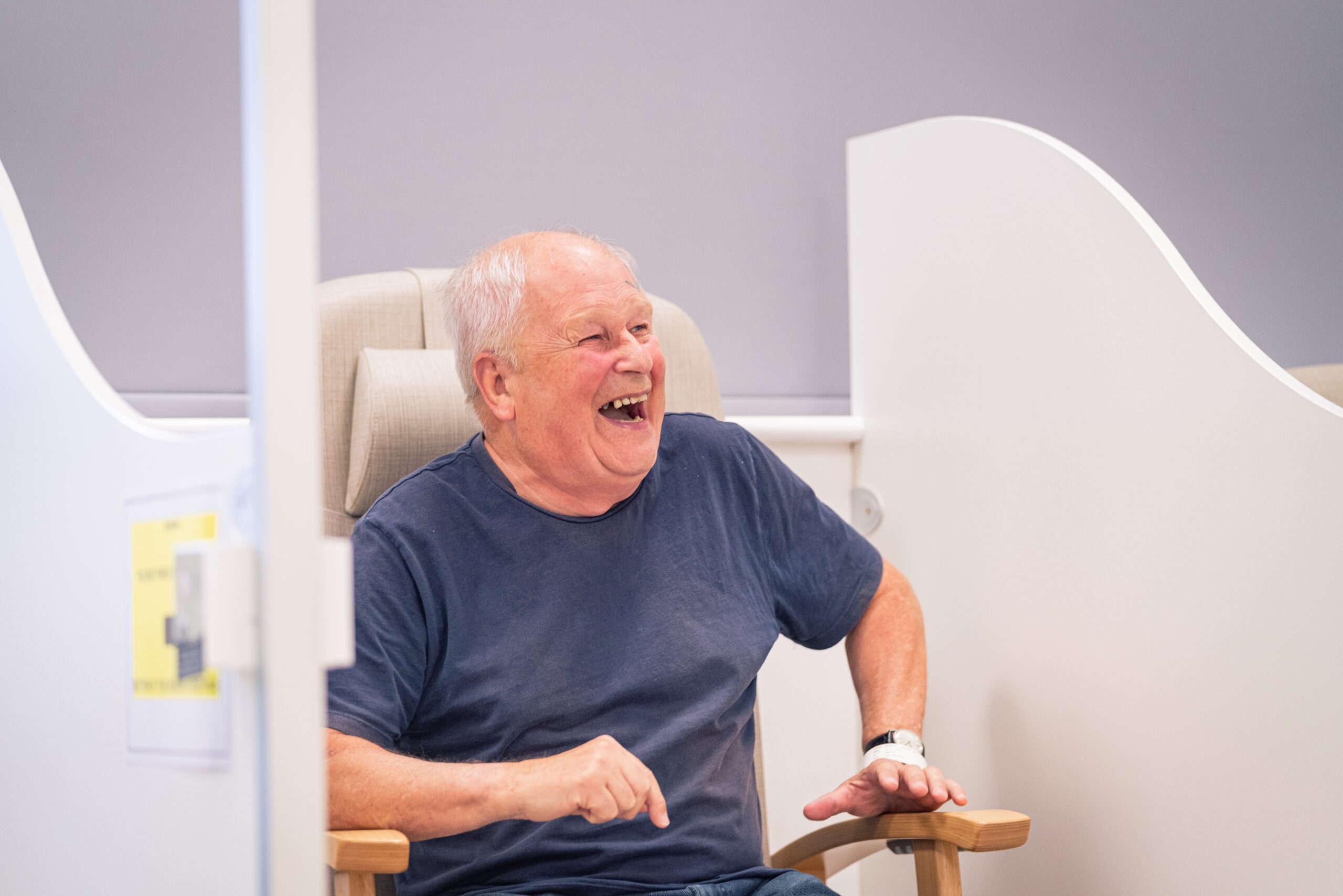 SpaMedica patient laughing and smiling whilst sat in a waiting room