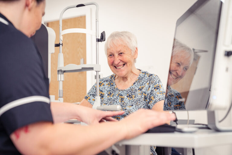 Happy SpaMedica patient having her eyes examined by a SpaMedica employee