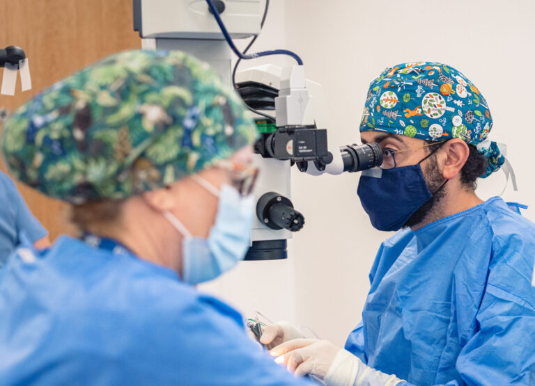 SpaMedica surgeon looking into a microscope and carrying out a cataract surgery