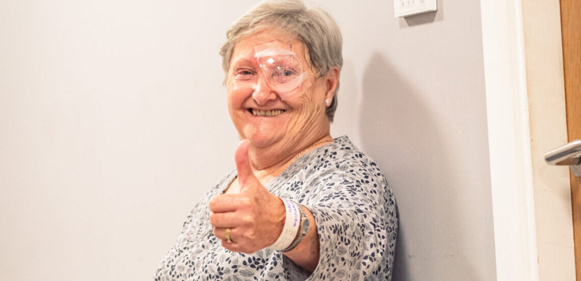 Happy SpaMedica patient in eye shield giving thumbs up