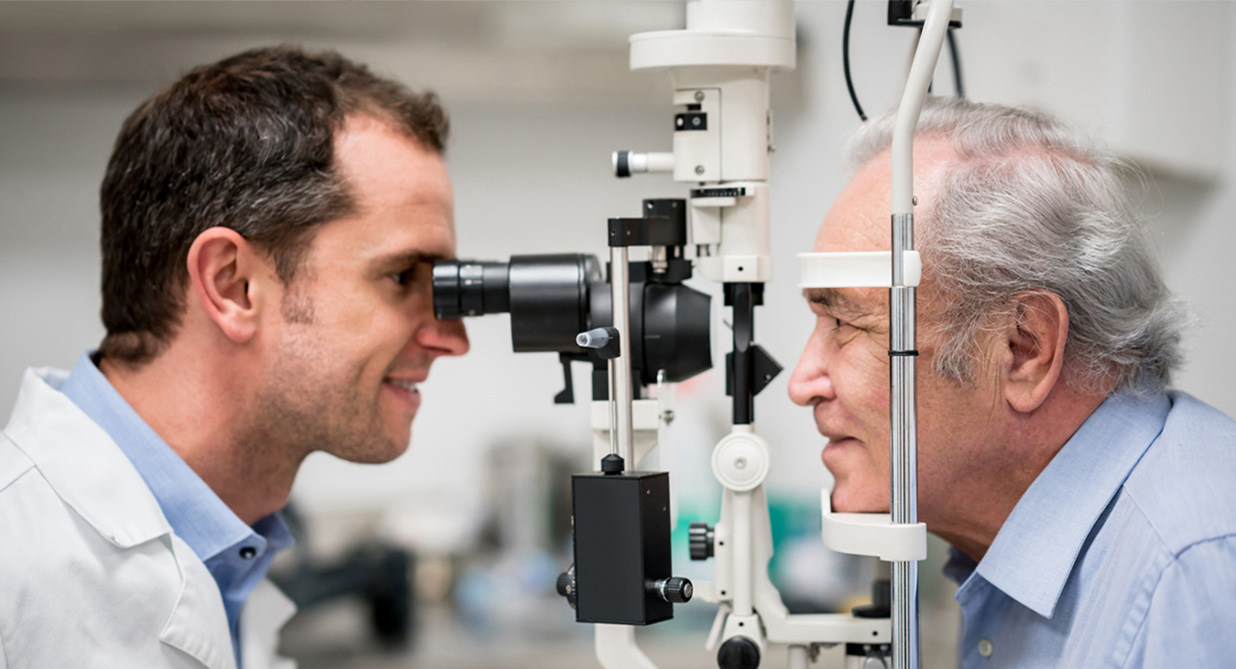 An optometrist carrying out an eye exam on an elderly gentleman