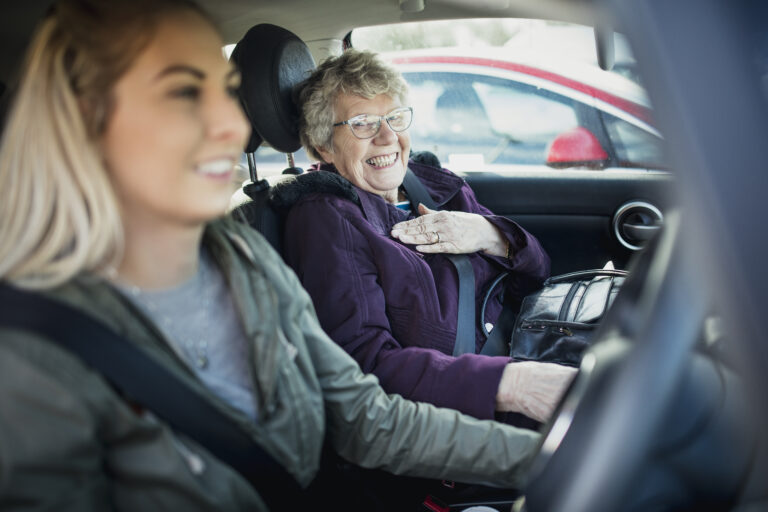 A grandmother and granddaughter in a car, with the granddaughter driving