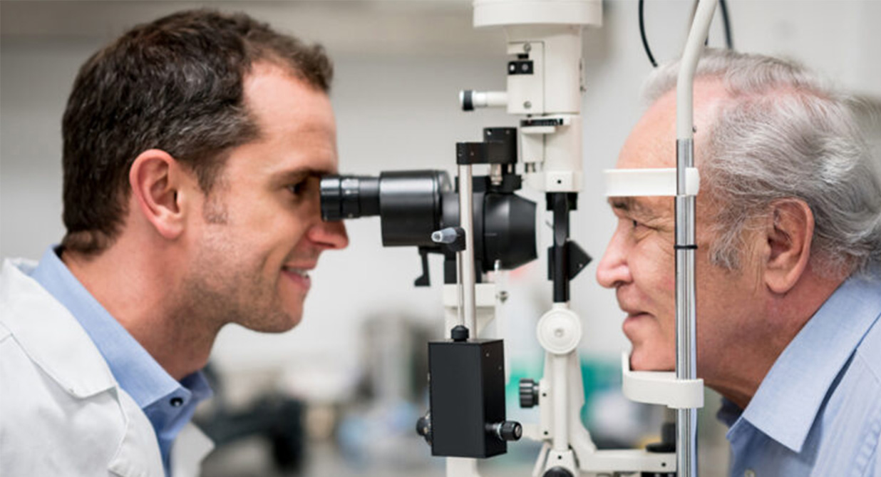 An optometrist carrying out an eye exam on an elderly gentleman