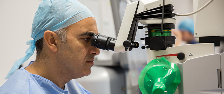 SpaMedica surgeon looking into a microscope and carrying out a cataract surgery