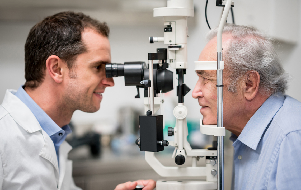 An optometrist carrying out an eye exam on an elderly gentleman