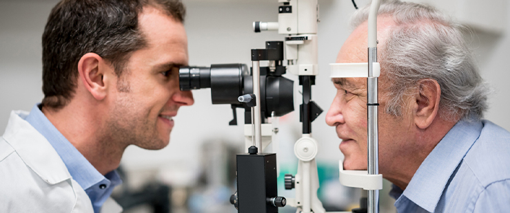 An optometrist carrying out an eye exam on an elderly gentleman