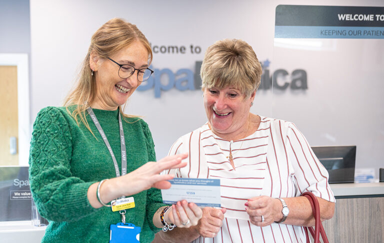 SpaMedica employee laughing with happy patient in reception