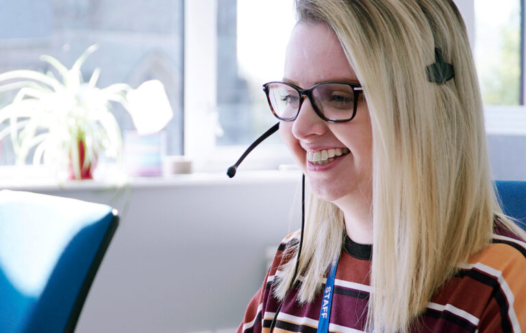 SpaMedica employee happily taking a call wearing a headset