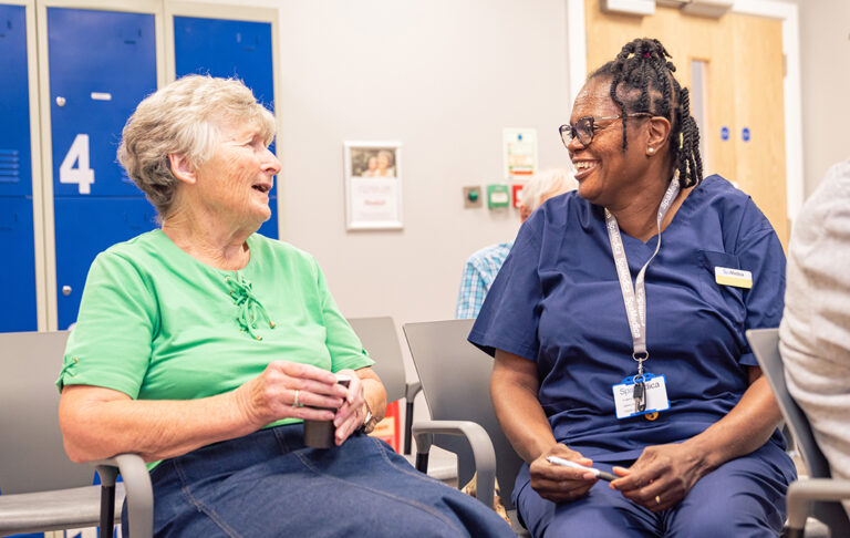 SpaMedica nurse in patient waiting room happily chatting with patient