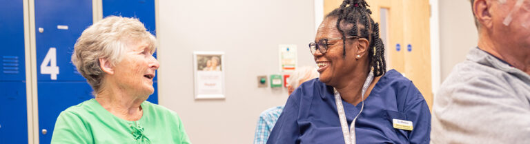 SpaMedica nurse in patient waiting room happily chatting with patient