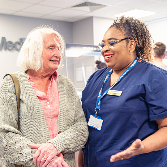 A happy SpaMedica patient sharing a joke and laughing with a SpaMedica employee after undergoing cataract surgery