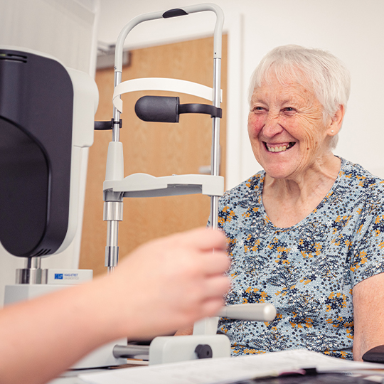 Happy SpaMedica patient having her eyes examined by a SpaMedica employee