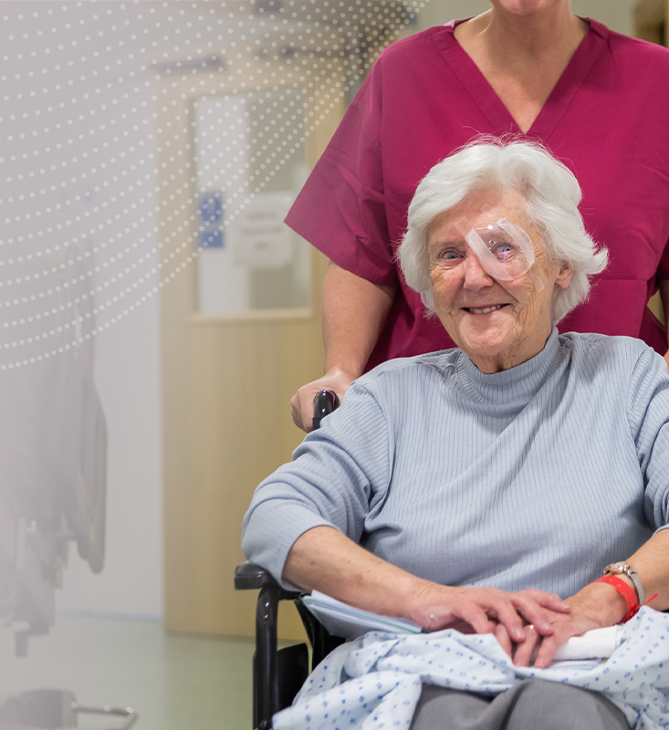 A smiling SpaMedica patient being helped back to the waiting room by a SpaMedica employee after undergoing cataract surgery