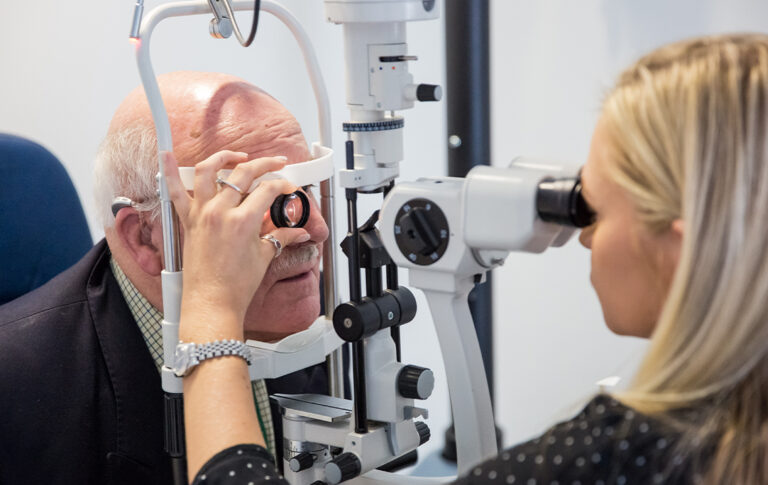 A SpaMedica Optometrist examining the eyes of a SpaMedica patient with a slit lamp