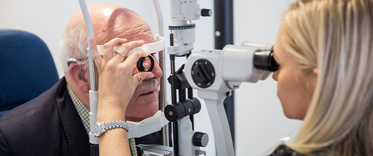 A SpaMedica Optometrist examining the eyes of a SpaMedica patient with a slit lamp