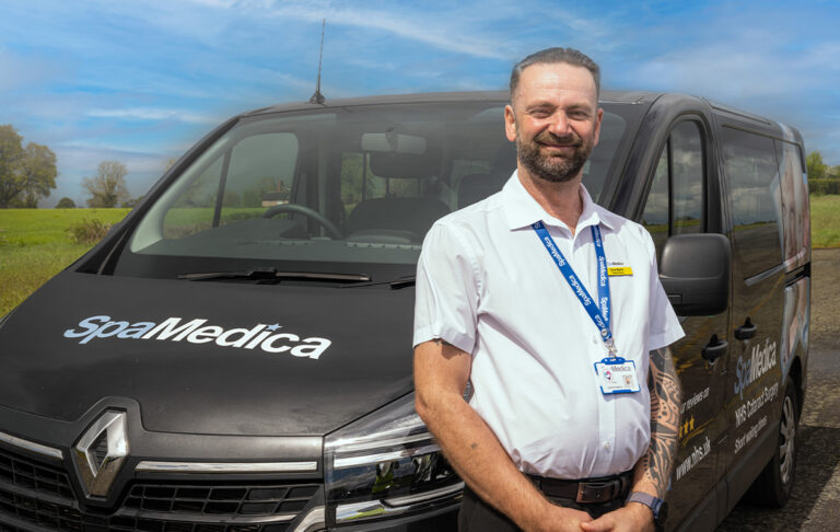 SpaMedica patient driver proudly posing next to his minibus