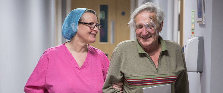 Happy SpaMedica nurse walking and chatting with patient post surgery