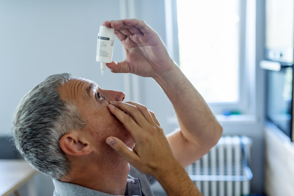 Photo of an elderly gentleman putting in some eye drops.