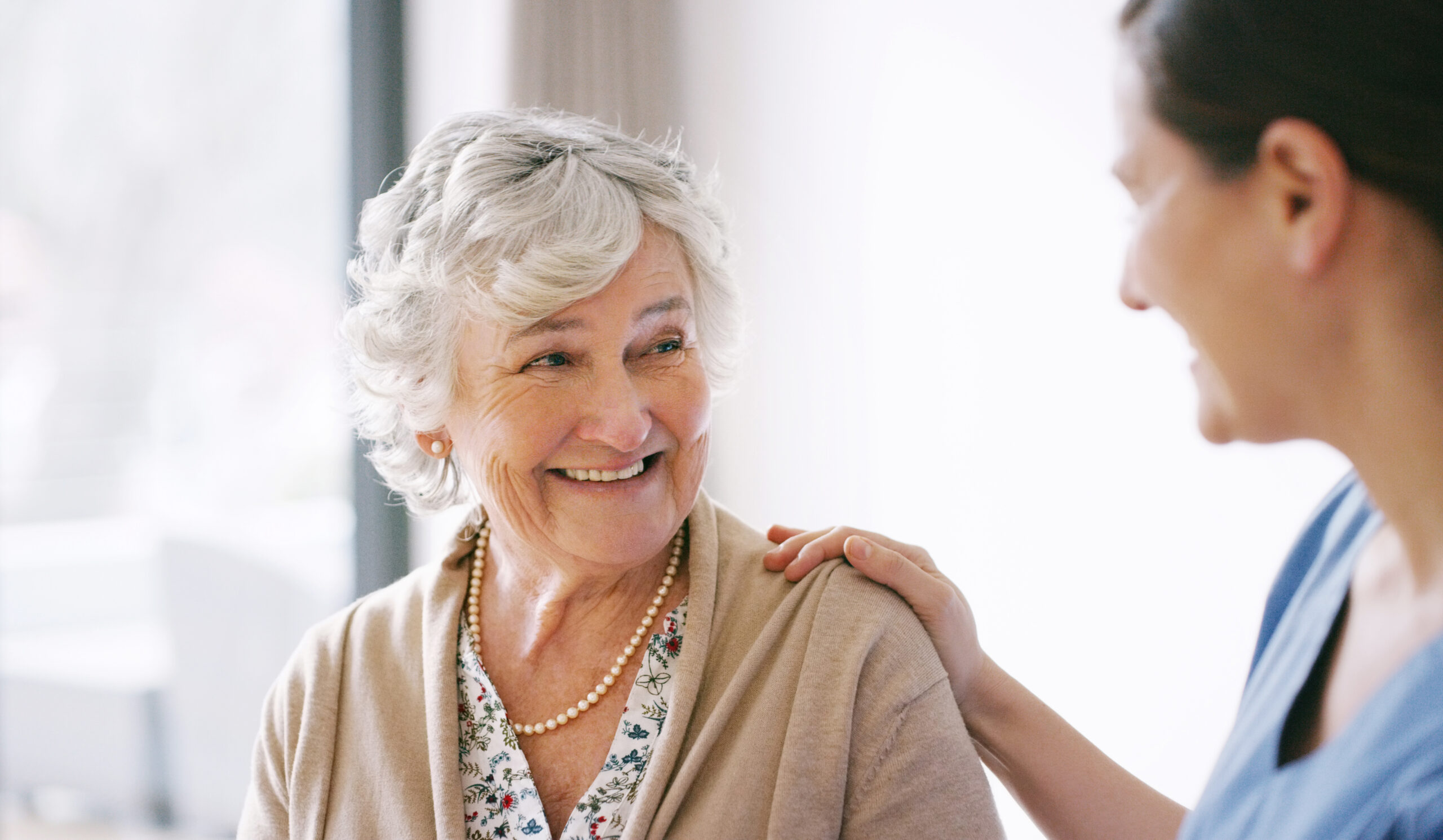 Senior women smiling at a nurse