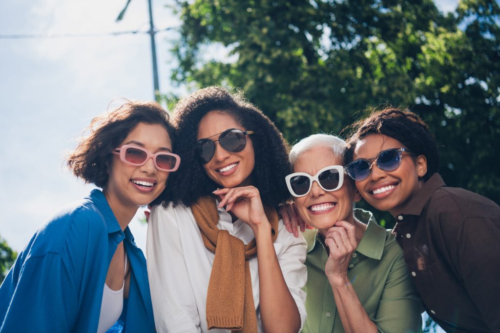 Photo of company friends women toothy beaming smile free time chill walk city park outdoors