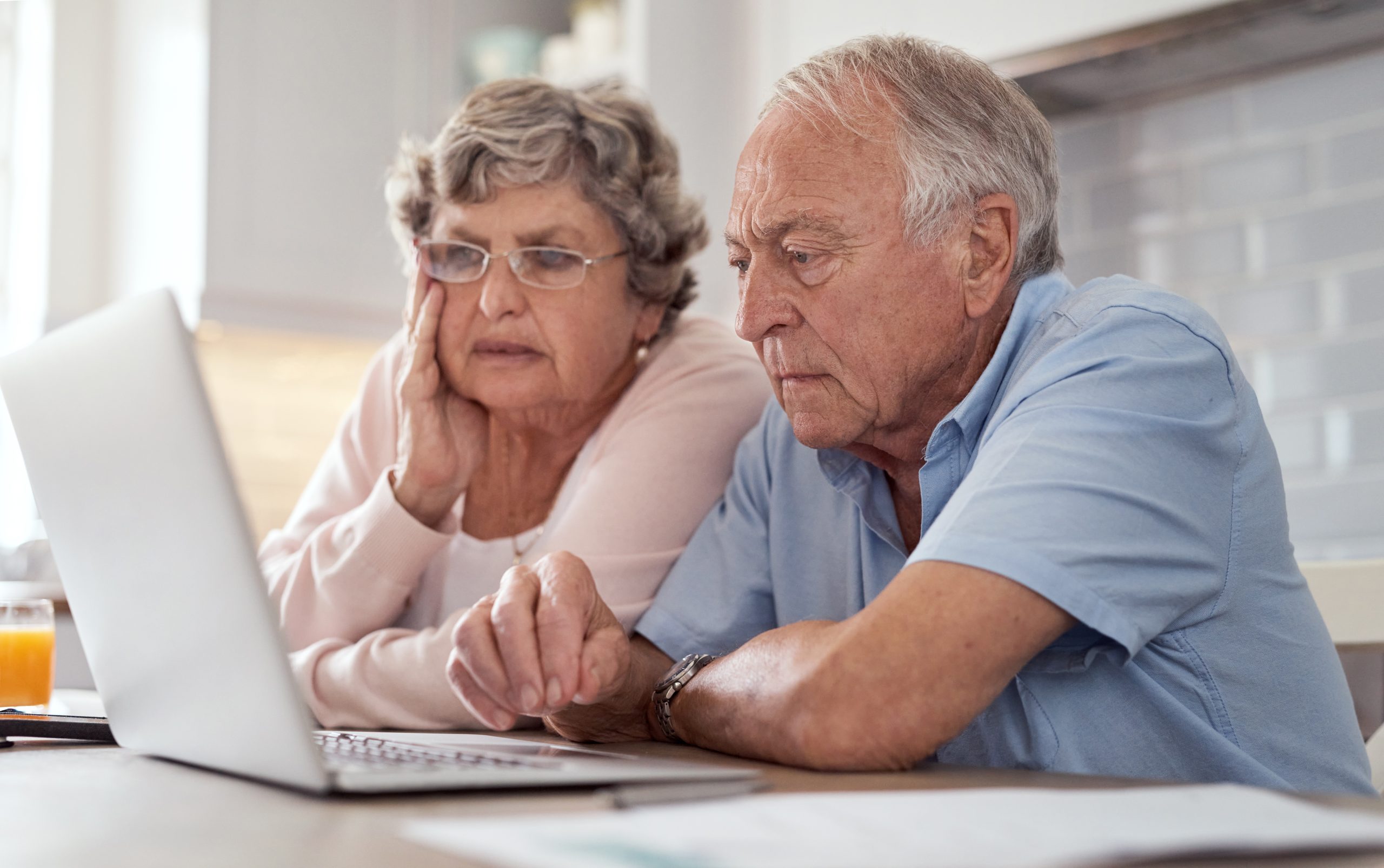 Shot of an elderly couple using a laptop together in the kitchen at home