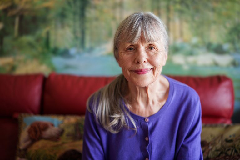 Happy smiling elderly female on sofa