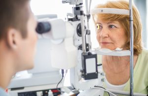 Elderly female having eyes examined with a slit lamp