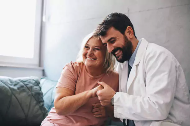 Female having happy conversation with male doctor
